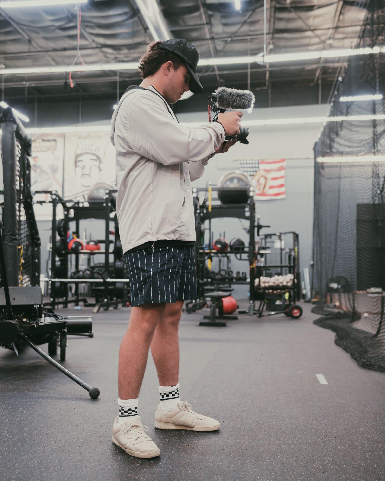 Leo Rochman filming with a camera inside a baseball training facility